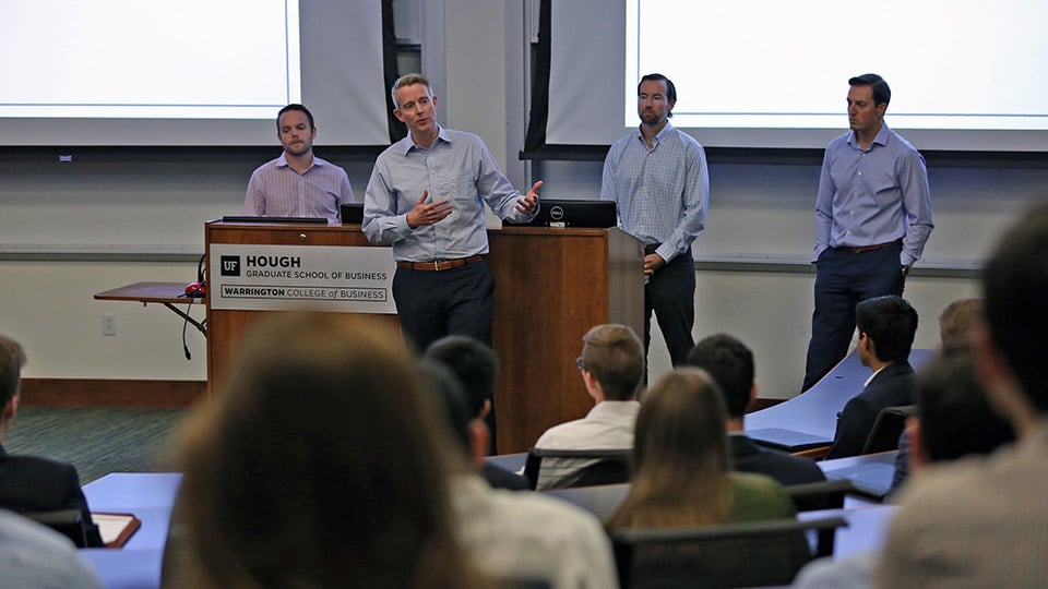 Speakers address students in a classroom