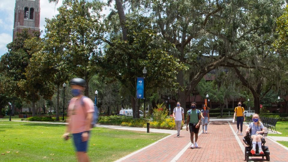 Students traversing through the Plaza of the Americas with Century Tower in the background