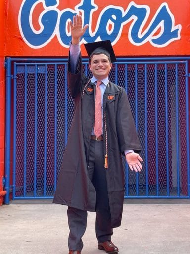 Daniel Abode does the Gator Chomp in his cap and gown