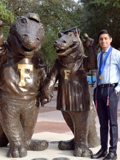 Kishan Patel stands with the Albert and Alberta Gator statues