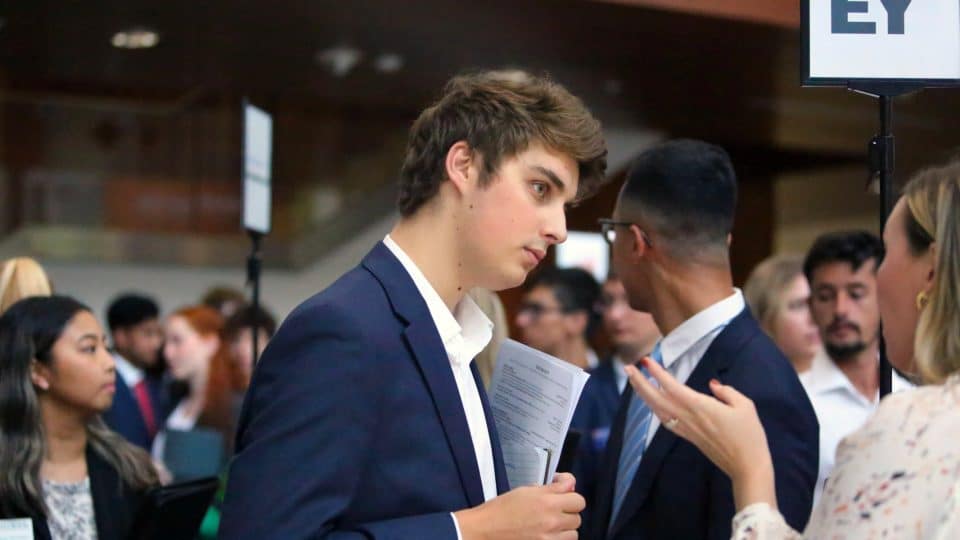 A student listens at a networking event