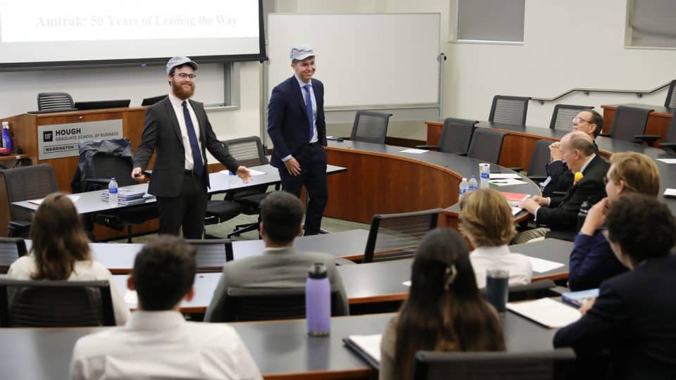 Two individuals presenting to a classroom of students