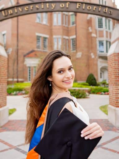 Ana Gjuraj under the UF gateway with Heavener Hall in the background