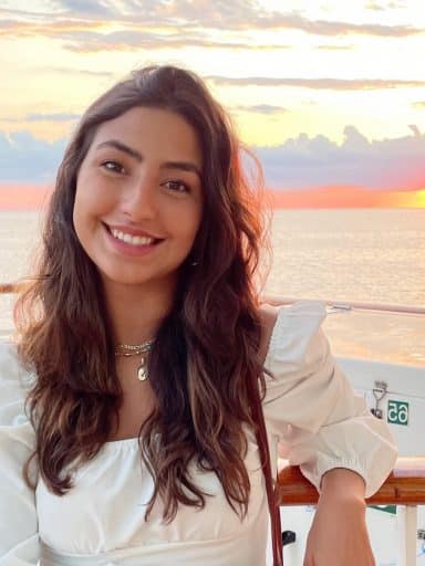 Kayla Freyre on a boat with a sunset in the background