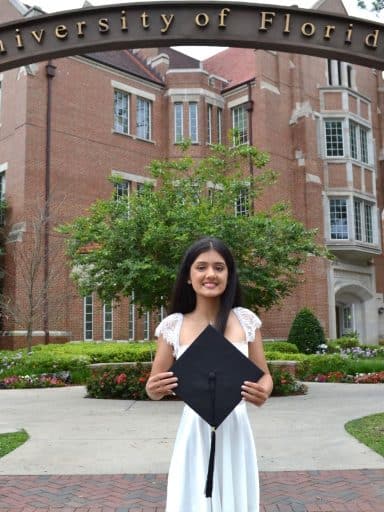 Kosha Patel under the UF gateway with Heavener Hall in the background