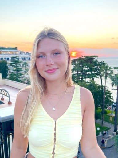 Leah Burkam on top of a building with a sunset in the background