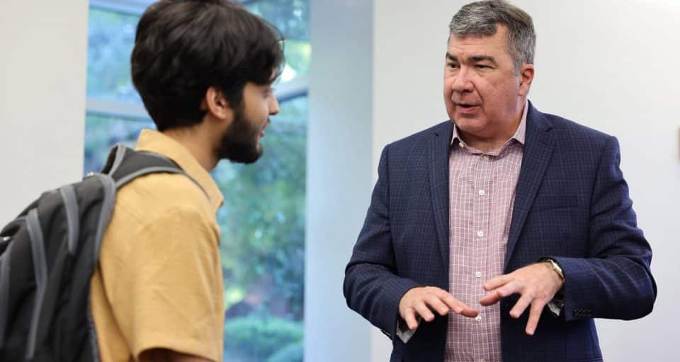 A businessman talks to a student