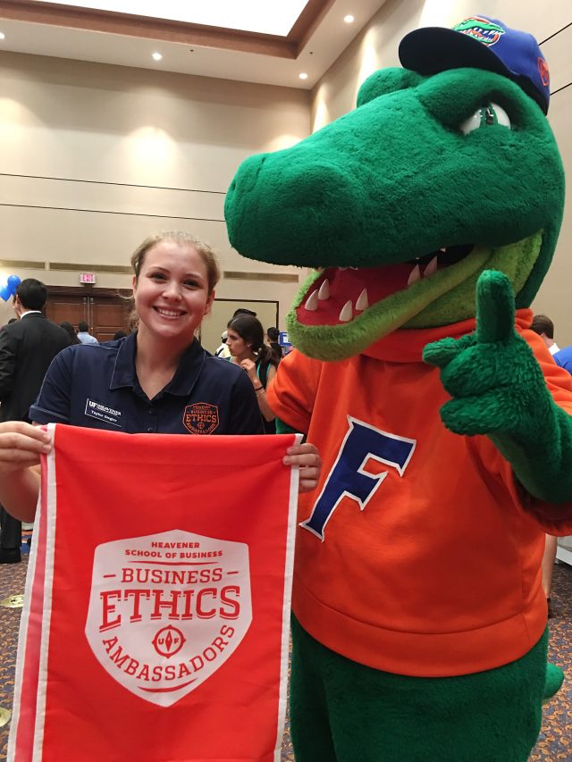 BEA student holding BEA banner next to Albert Gator