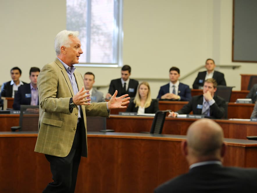 David Ling speaks to a classroom as students look on