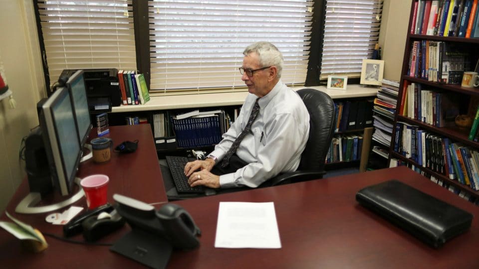 Wayne Archer in his office working on his computer