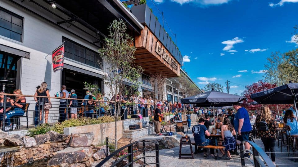 Outdoor seating space for a restaurant with a lot of people eating and socializing