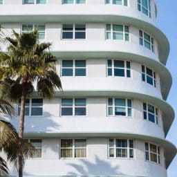 An apartment building with palm trees beside it