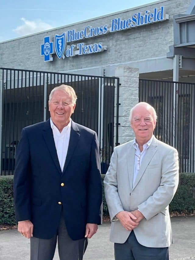 Kelley Bergstrom and Jerry Tate stand in front of a Blue Cross Blue Shield