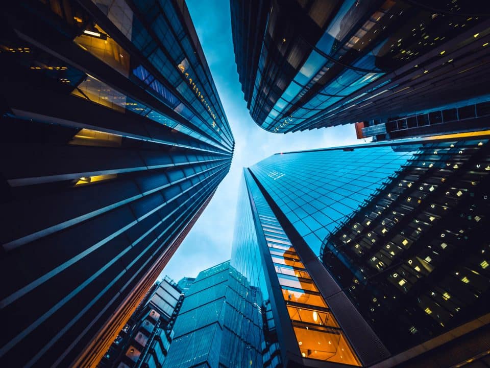 Looking skyward at the base of three tall buildings