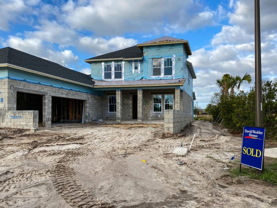 A house under construction with a sold sign out front