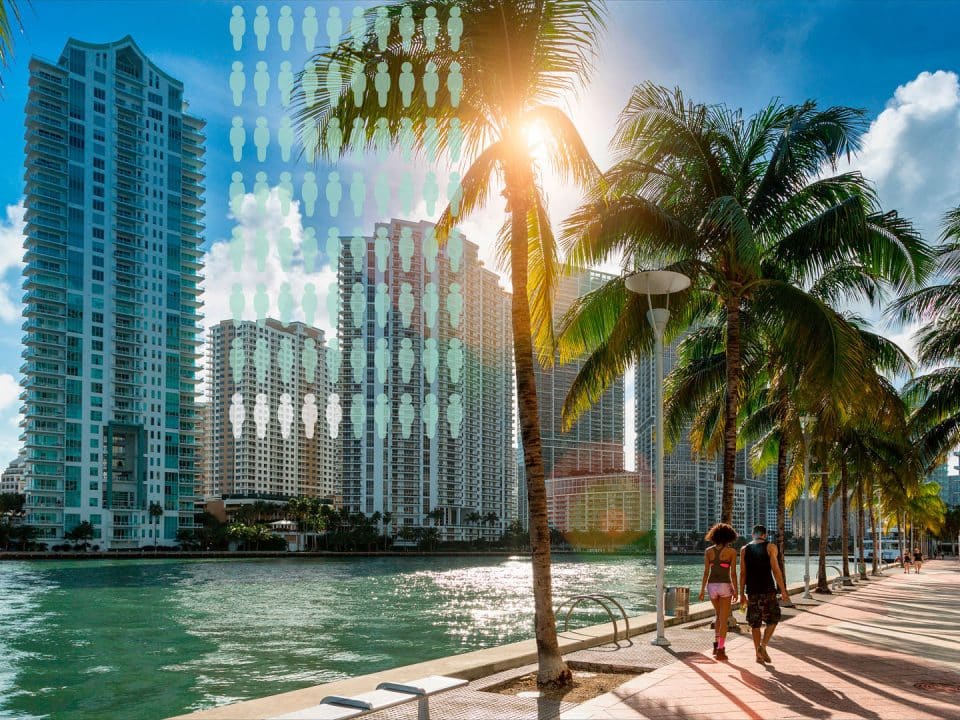 Two people walk along water by palm trees and tall buildings in the background with a population graphic overlay