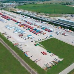 An aerial view of an industrial storage facility where many trucks and storage containers are parked