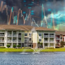 Apartment buildings with a retention pond in the foreground and chart lines overlaid on the sky in the background