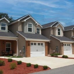 A row of new townhouses with garages along a street