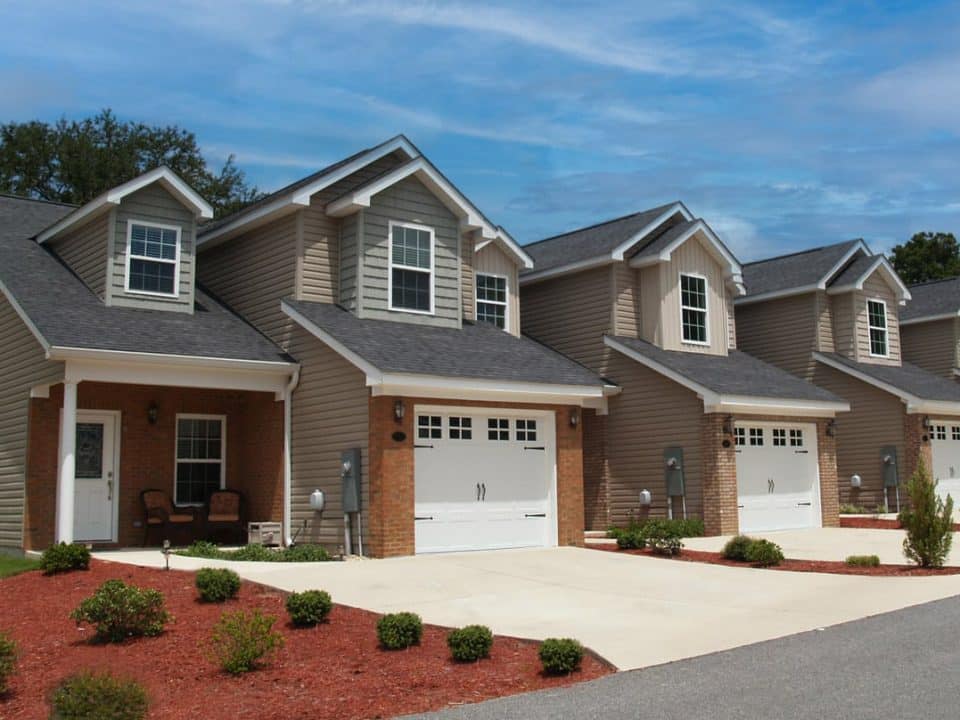 A row of new townhouses with garages along a street