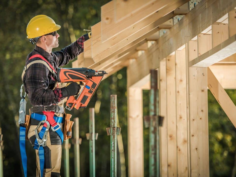 A construction framer at work with a nail gun