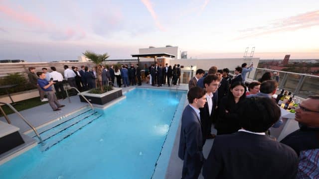 FIC attendees and speakers networking around the pool on the top of the AC Hotel Gainesville