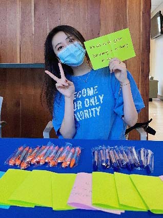 Ambassador at table with orange and blue pens and colored papers