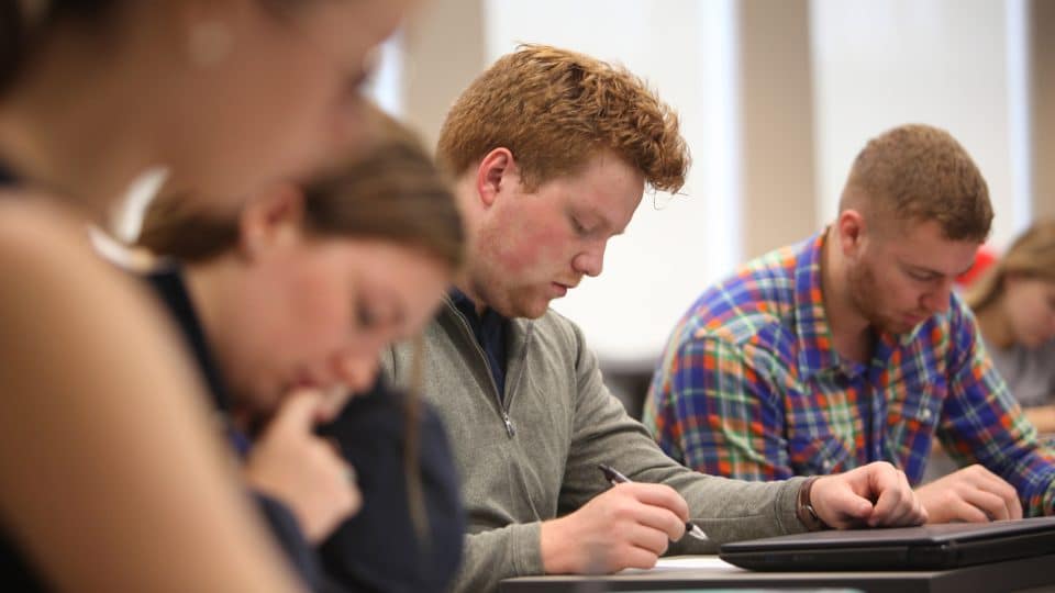 Students looking down as they work in a classroom