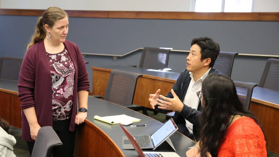 Faculty Megan Mocko listens to a student in class