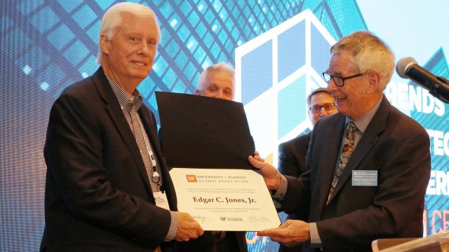 Edgar Jones is presented an Honorary Alumnus of the Year award by Wayne Archer as David Ling and Tim Becker look on at the Trends and Strategies Conference