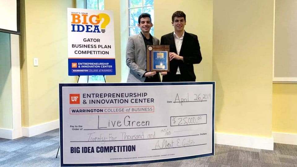 Two students accept the award and ,000 check for the Big Idea Gator Business Competition Plan