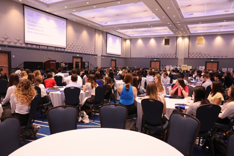 A large crowd of students watch a speaker at the Warrington Welcome Professional Development Summit.