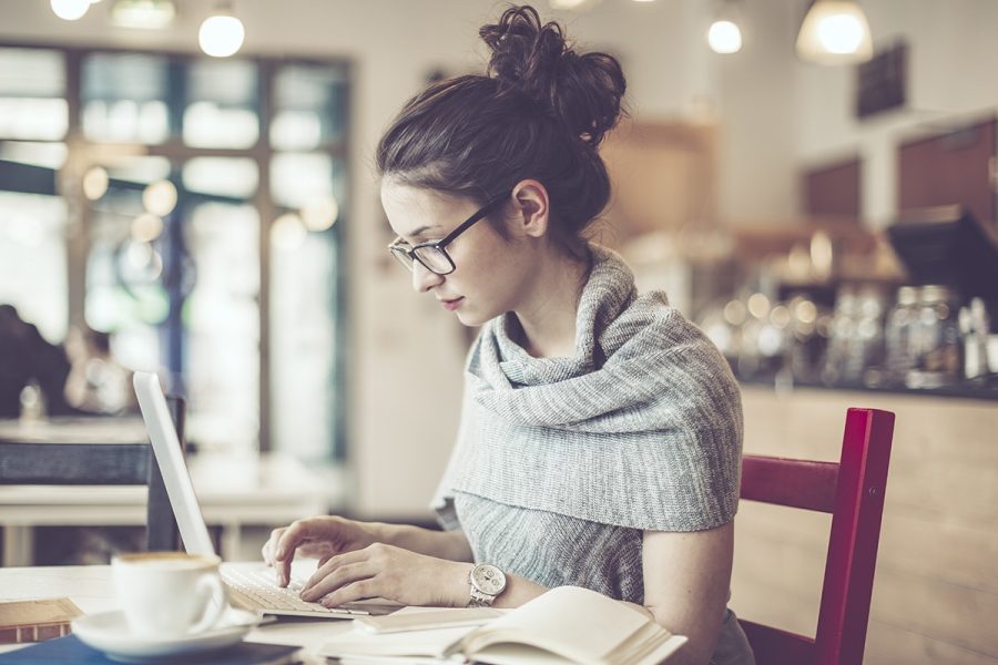 Woman working on her laptop in a coffee shop