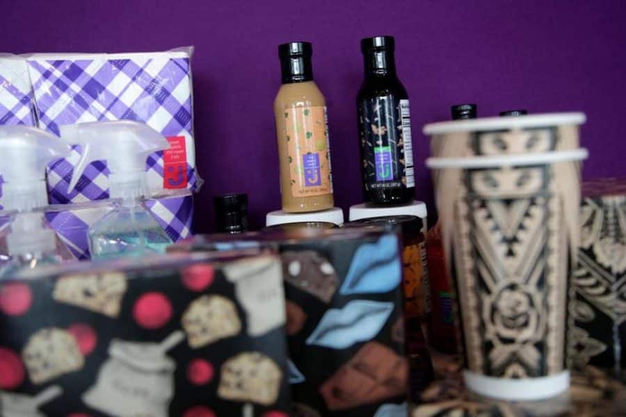 Two bottles of salad dressing with other products like cups and napkins