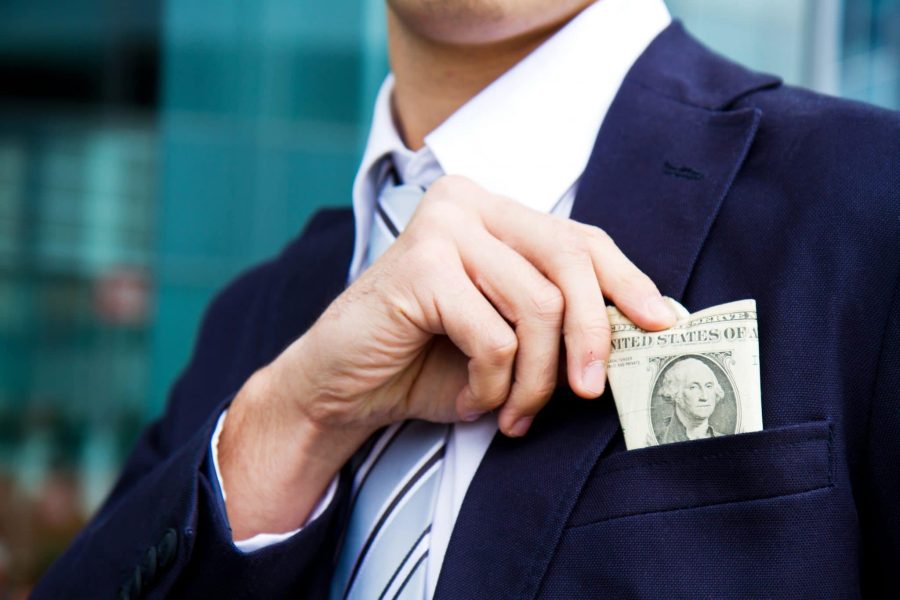 Business man putting money in his jacket pocket