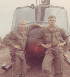 Art Jacobs as an Air Rescue Pilot in Vietnam stands in front of a helicopter with another serviceman