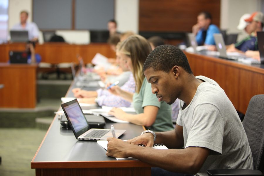 A row of students taking notes in class