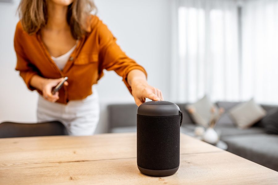 Young woman turning on a wireless smart column at home