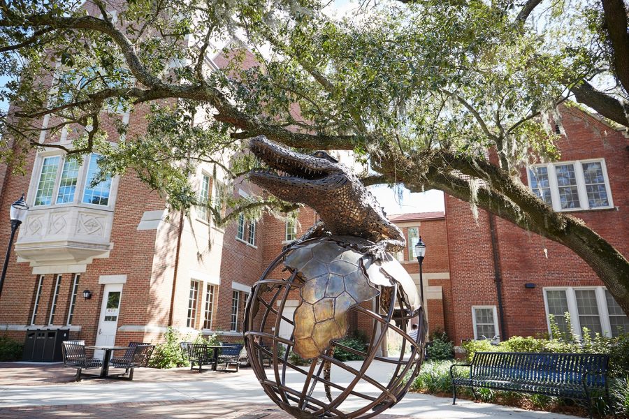 Gator Ubiquity Statue with Heavener Hall behind on a sunny day
