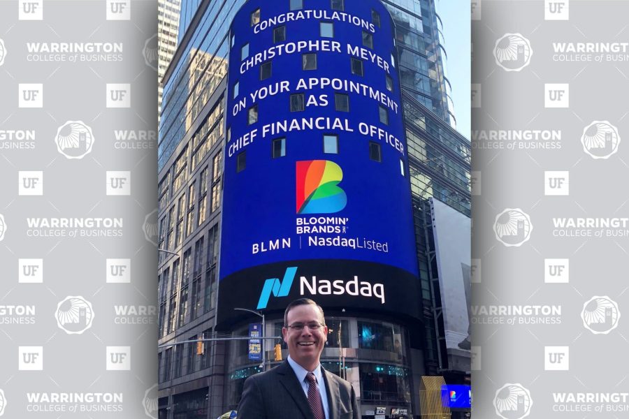Chris Meyer stands in front of a digital sign in New York City that reads 'Congratulations Christopher Meyer on your appointment as Chief Financial Officer" with the Bloomin' Brands logo and NASDAQ logo.