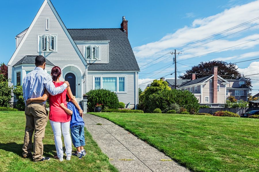 A young mixed-race family admiring a home - possibly their first home, or the home they hope to own.