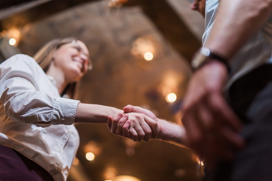 Looking up at a young woman shaking hands with another person