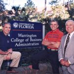 John Kraft, Al Warrington and Robert Lanzillotti pose for a photo in front of the Warrington College of Business sign