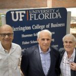 Saby Mitra, John Kraft and Robert Lanzillotti pose for a photo in front of the Warrington College of Business sign