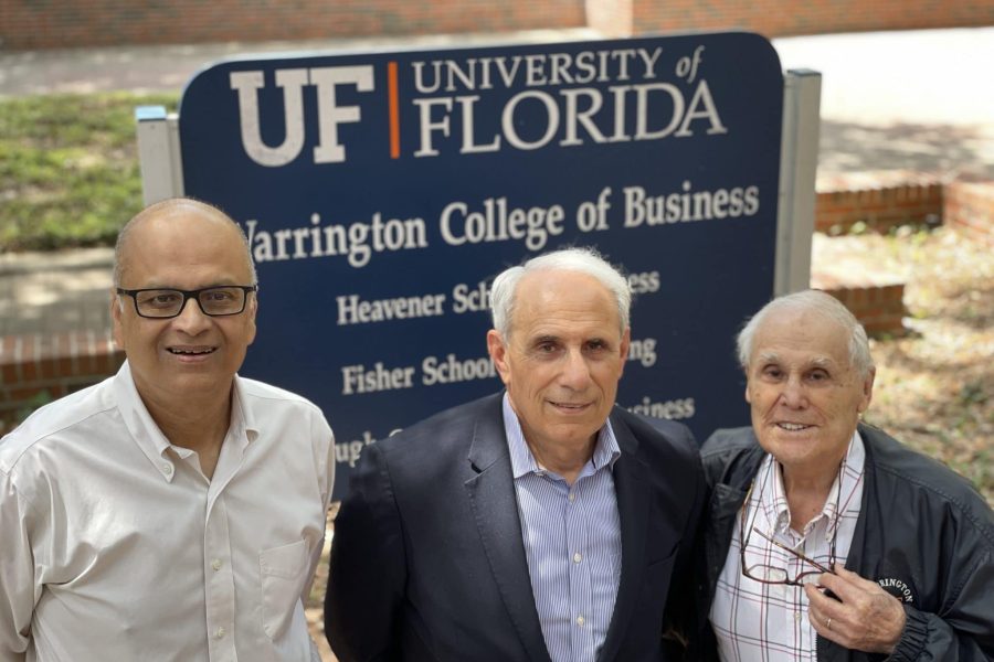 Saby Mitra, John Kraft and Robert Lanzillotti pose for a photo in front of the Warrington College of Business sign