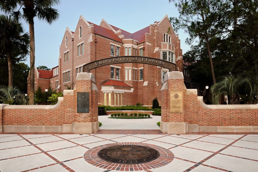 University of Florida entrance with archway and view of Heavener Hall in the background.