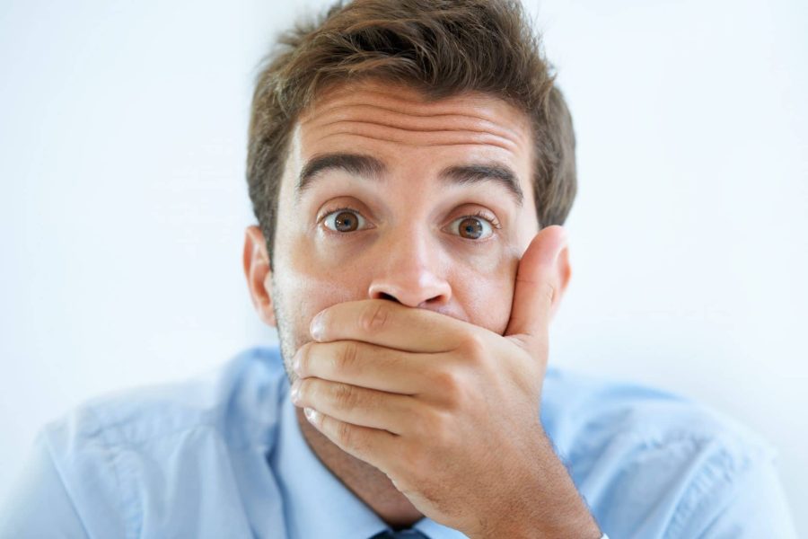 Portrait of a young businessman covering his mouth with his hand
