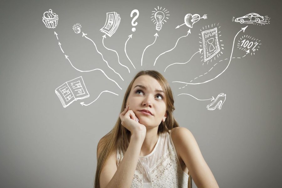 Young woman looking up while thinking about various things - books, money, diploma, shopping, ideas and love.