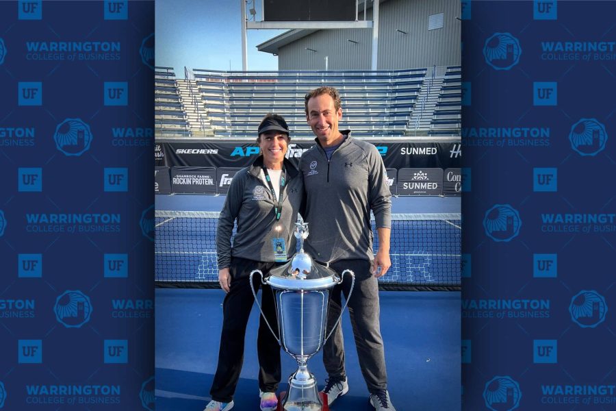 Brian Levine stands with a teammate next to a trophy.