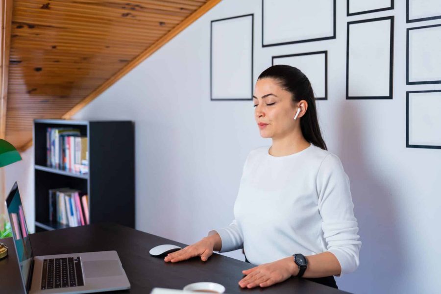 Relaxed calm businesswoman takes deep breath resting with eyes closed at work in home office.